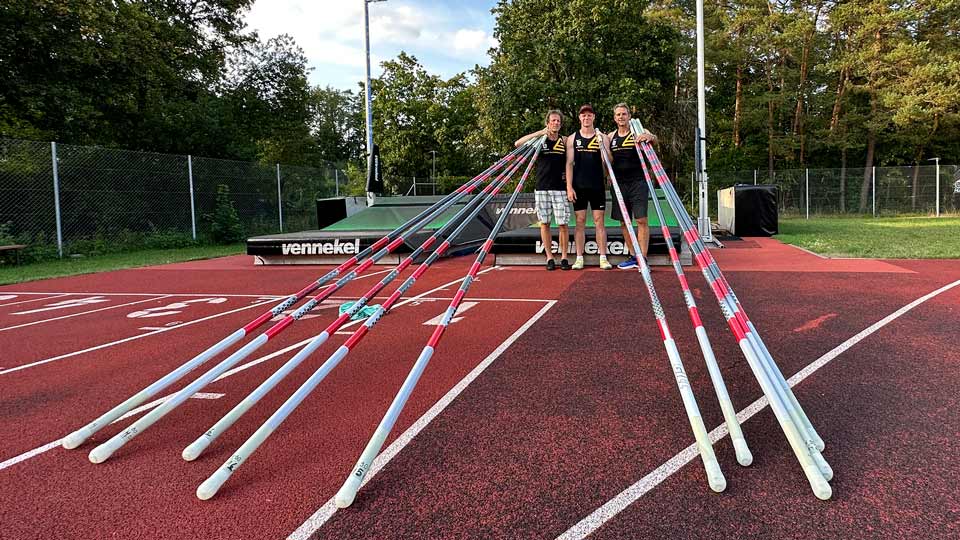 TSV Gräfelfing coaches and support staff stand together with decathlete Felix Wolter and hold new Pacer brand pole vault poles